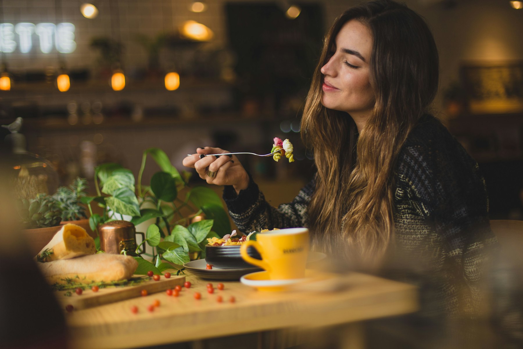 Una mujer almorzando tranquila en una mesa junto a una ventana