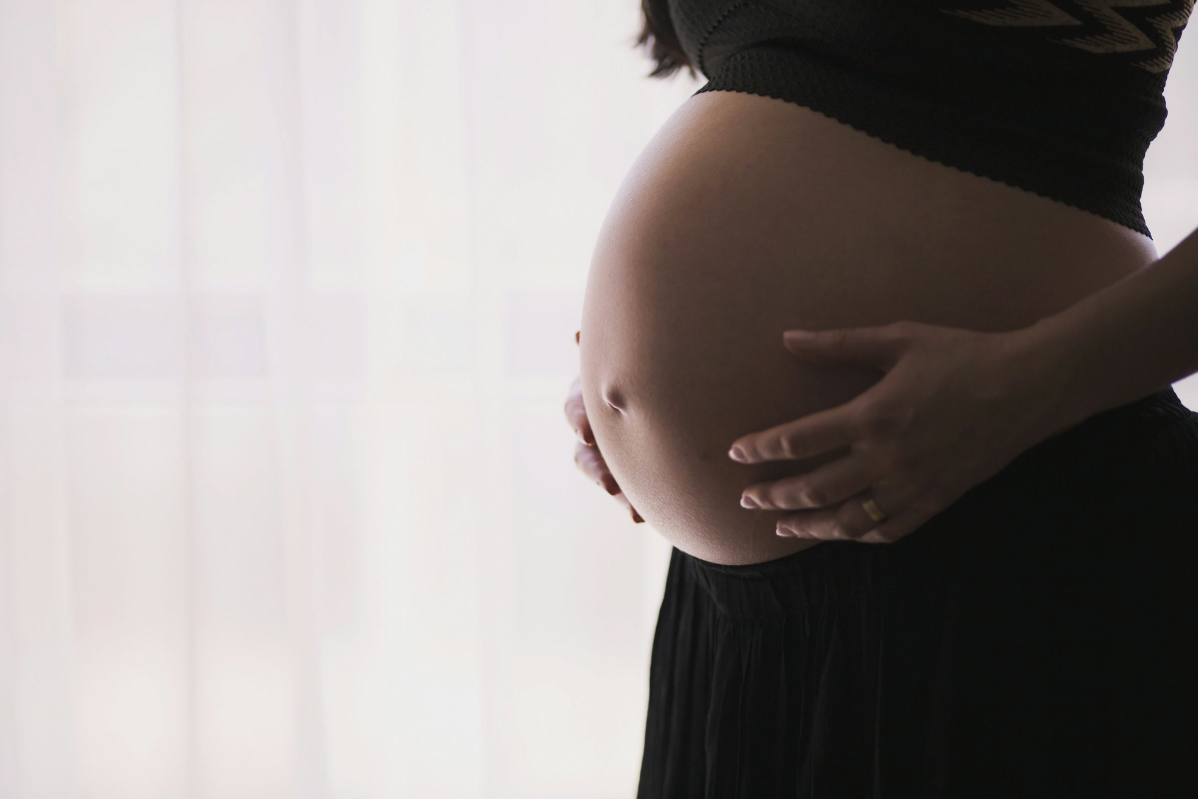 Mujer embarazada con las manos apoyadas sobre su panza